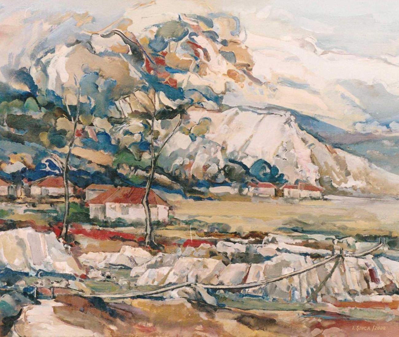 A white hill with blue-green vegetation, red-roofed houses and a stony bank above water.