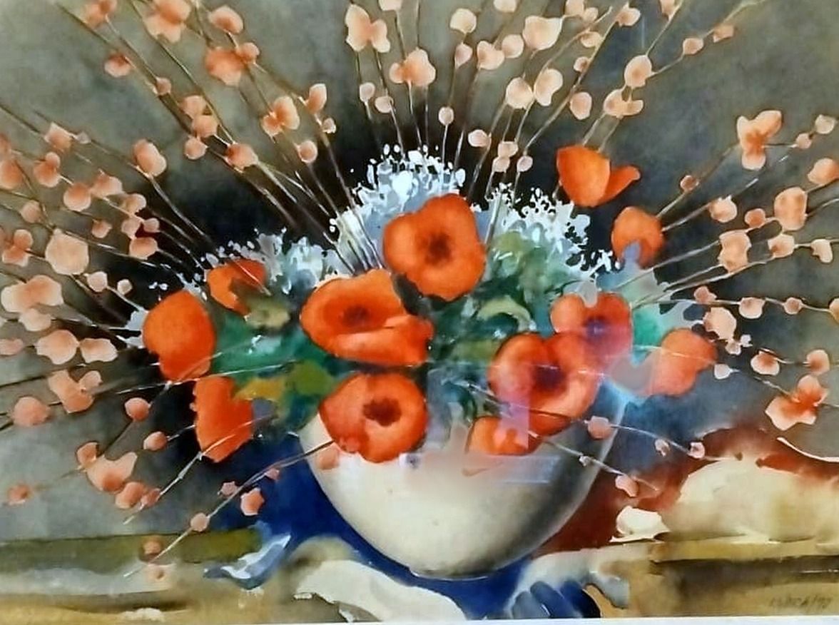 Red poppies in a white and blue bowl among long branches of small pink flowers, on a grey-green ground.